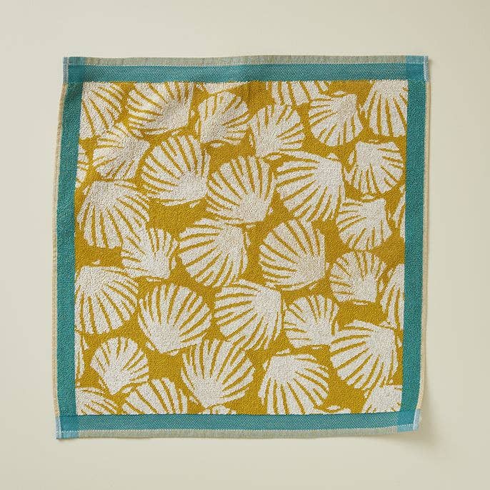 GULE MUSLINGER Gæstehåndklæde 50x50 cm. Design med gule og hvide muslinger med en turkis kant.