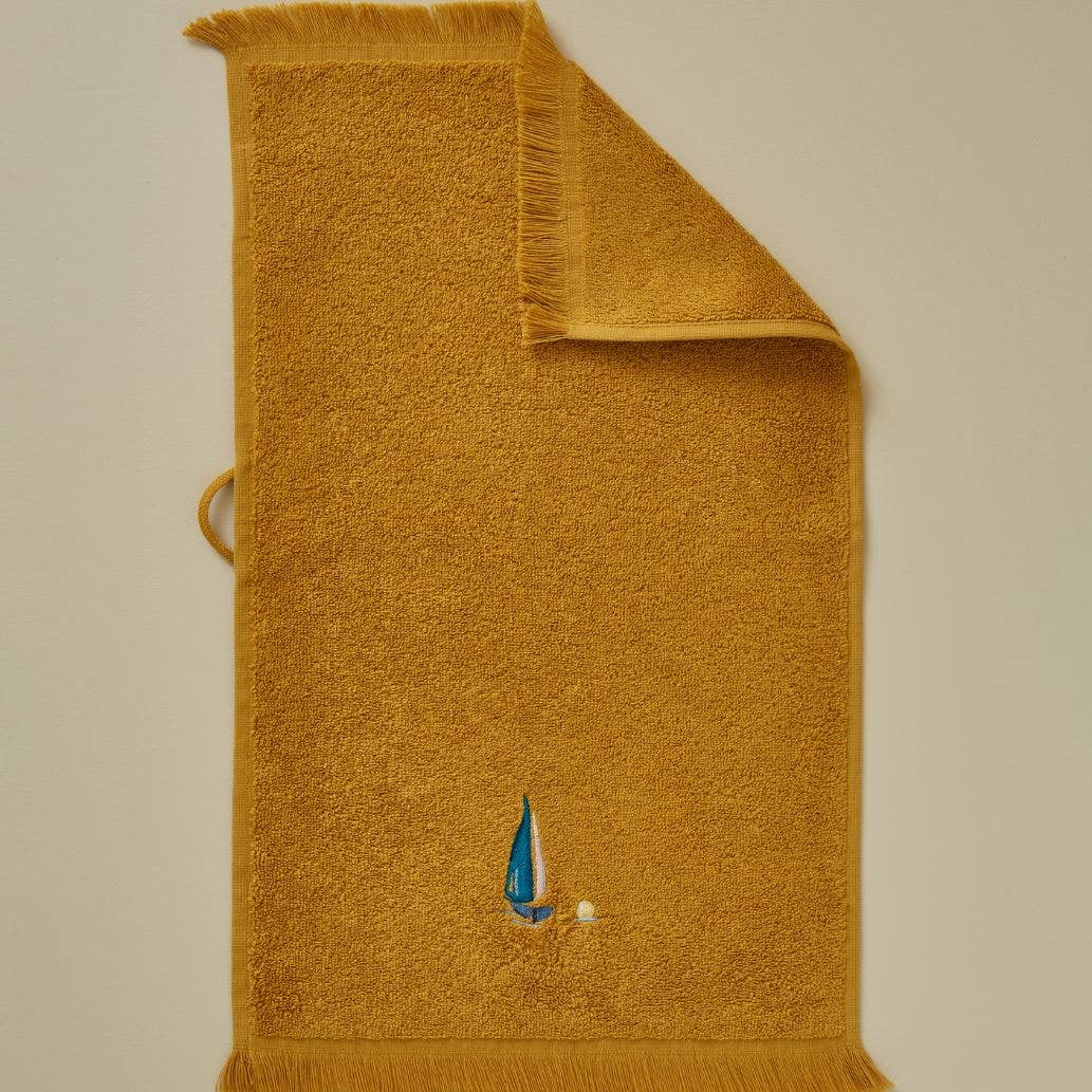 HONNINGGUL SEJLBÅD Gæstehåndklæde 30x50 cm. Design med en lille broderet sejlbåd på en honninggul bund.