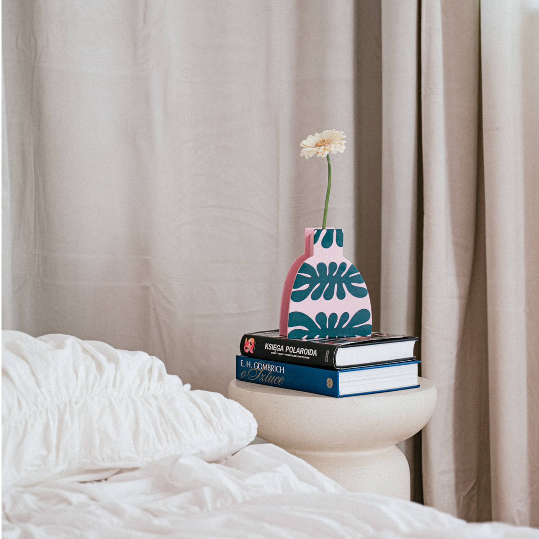 Pink og grøn trævase med blomster i farverig stue