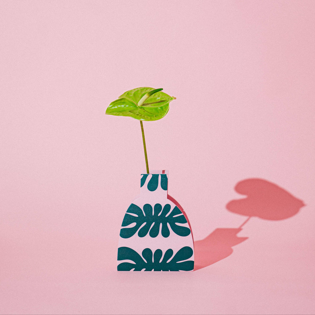 Pink og grøn trævase med blomster i farverig stue