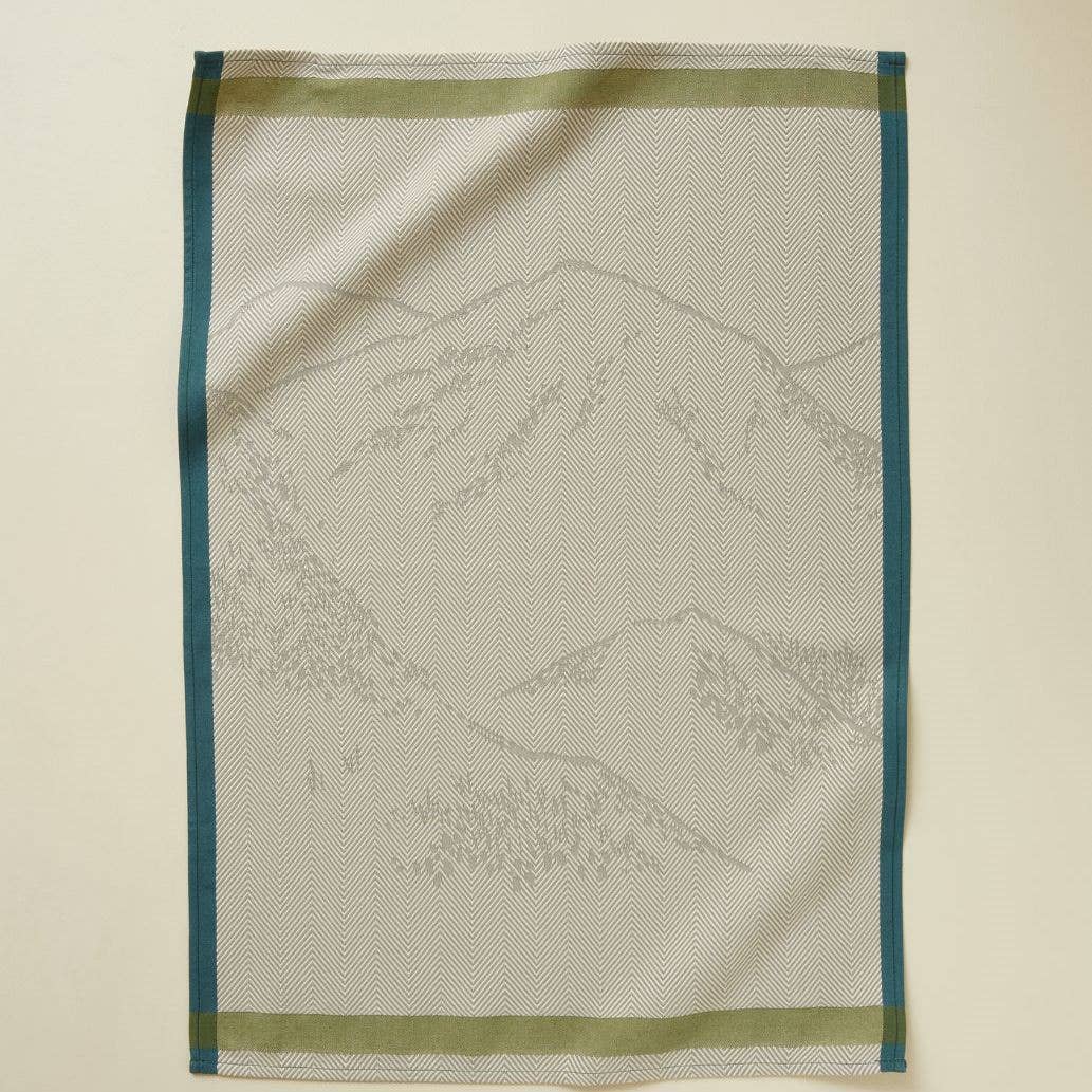 GRØNNE BJERGE Viskestykke. Design med et diskret bjergmotiv på en lys bund med grønne og blå kanter.