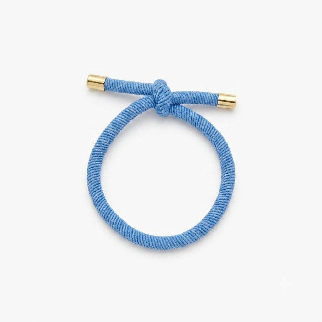 BLÅ Hårelastik og armbånd båret som armbånd om håndleddet.