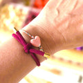 BORDEAUX Hårelastik og armbånd båret sammen med et armbånd med et pink hjerte.