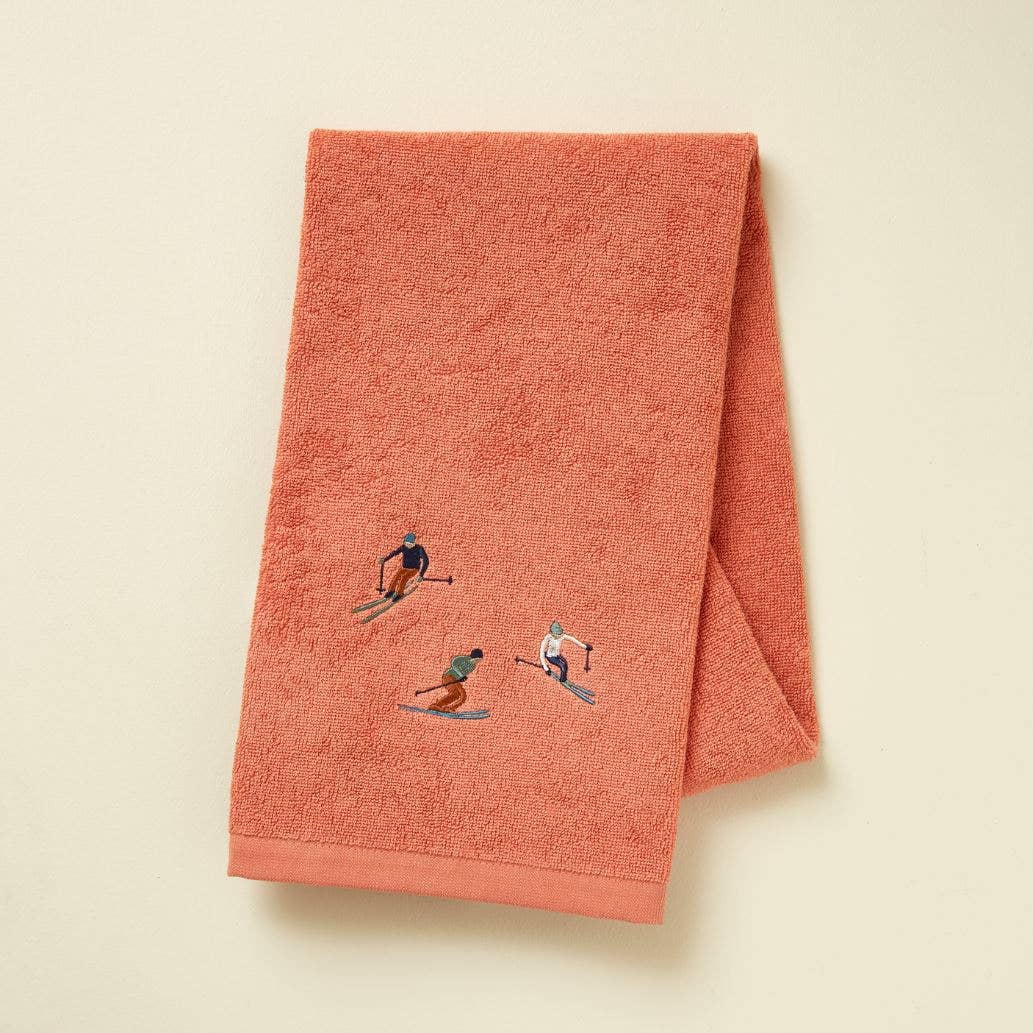 ROSA SKILØBERE Håndklæde 50x100 cm. Design med små broderede skiløbere på en varm rosa bund.